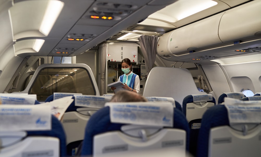 a woman in a face mask sitting on an airplane