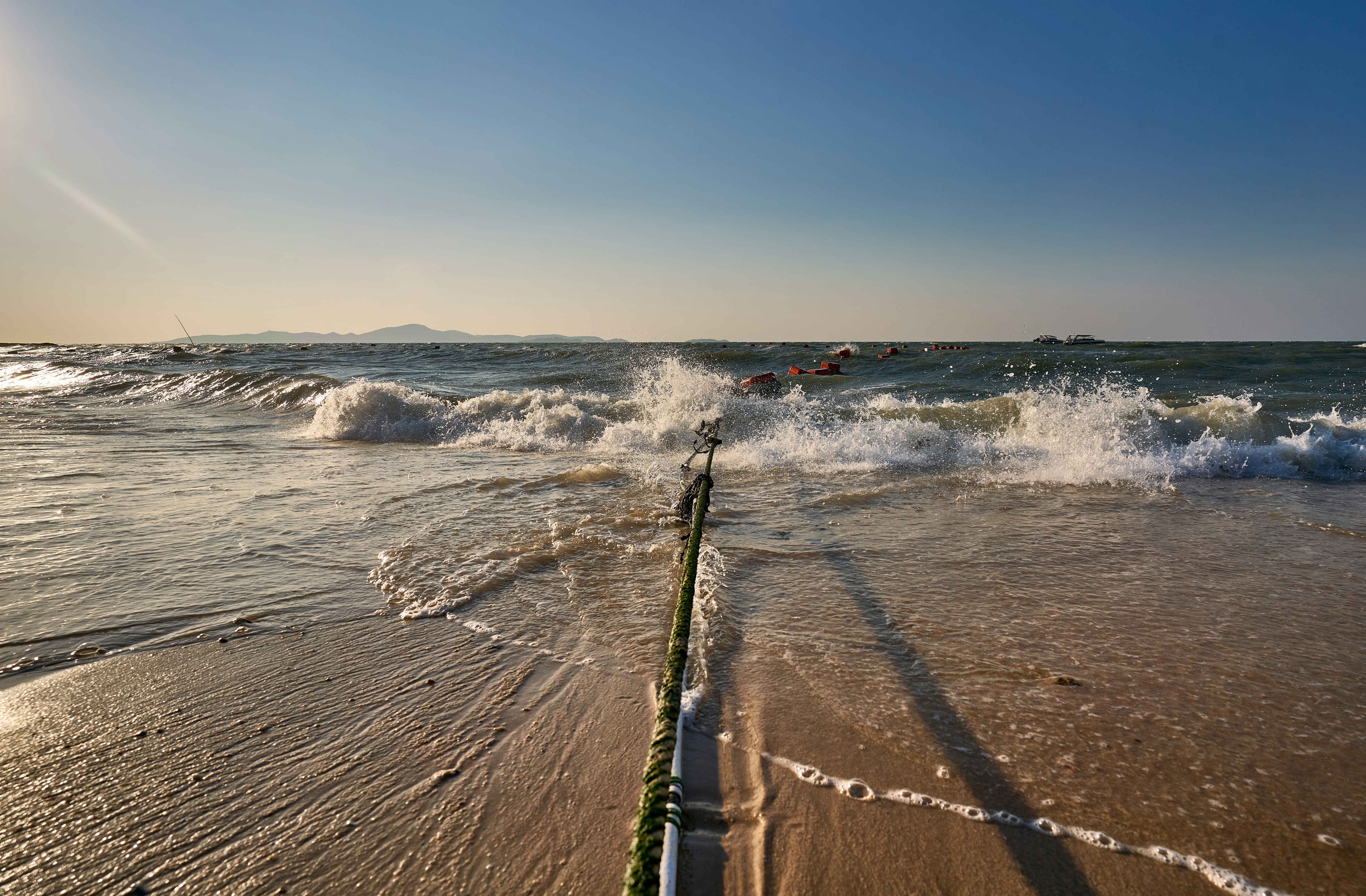 a fishing rod sticking out of the water on a beach