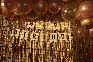 a happy birthday banner with balloons and streamers