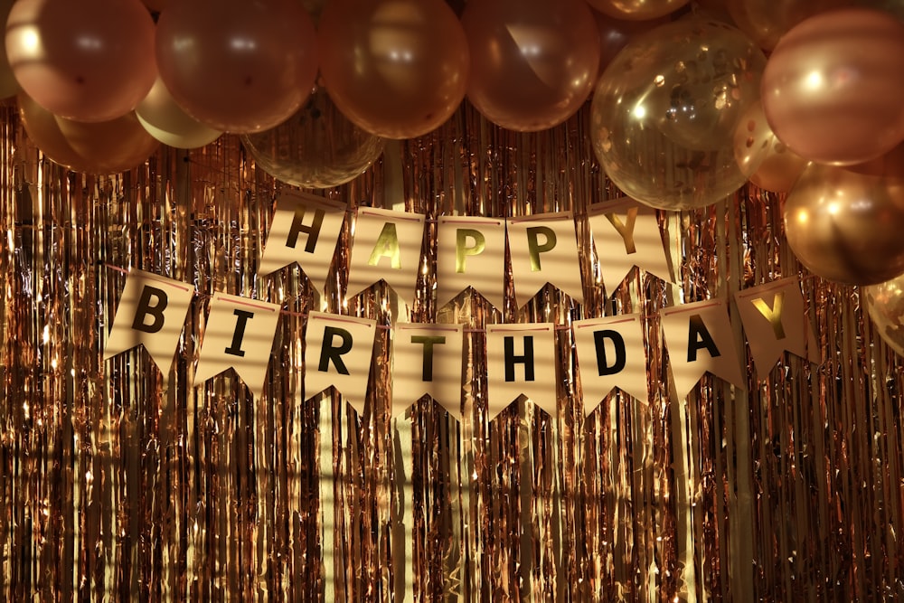 a happy birthday banner with balloons and streamers