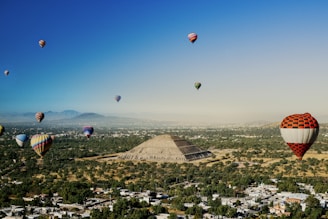 a group of hot air balloons flying over a city