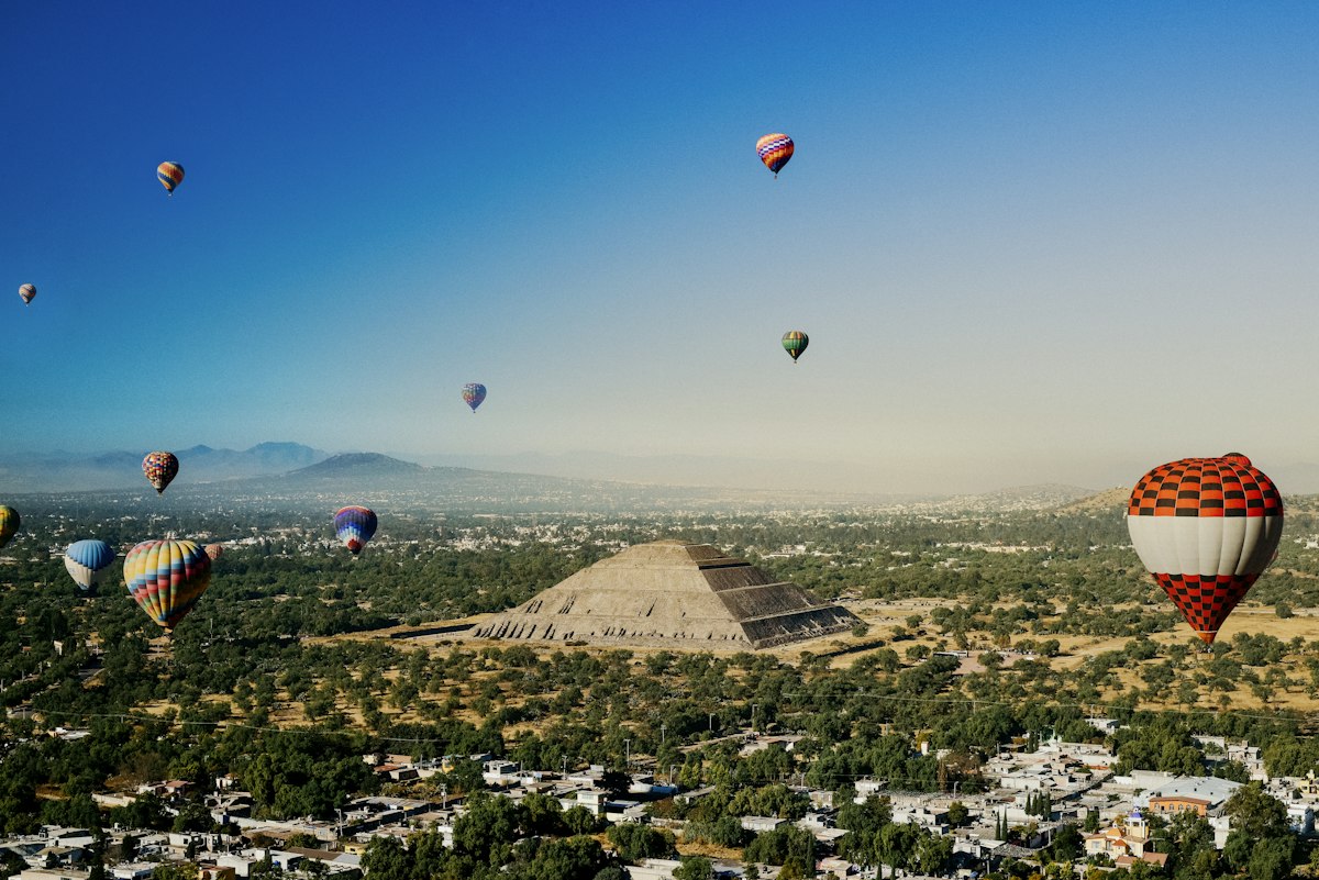 Mongolfiere coloratissime che sorvolano le piramidi di Teotihuac&aacute;n al tramonto, Messico