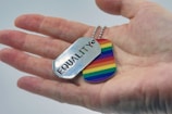 a person holding a rainbow dog tag in their hand