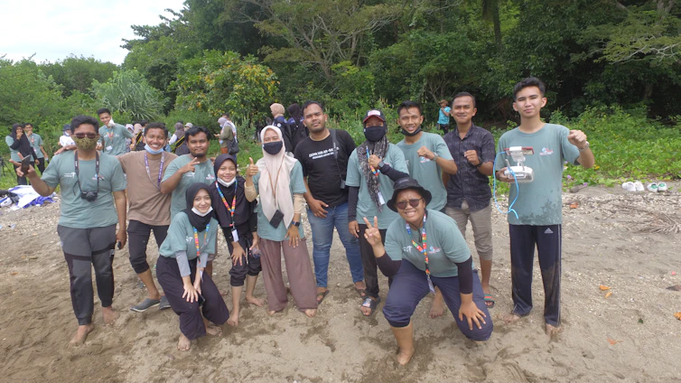 Creative team capturing vibrant outdoor scenes with cameras and drones on a sunny beach setting.