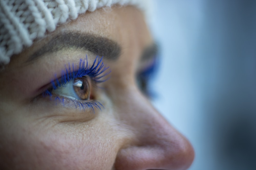 a close up of a woman's face with blue makeup