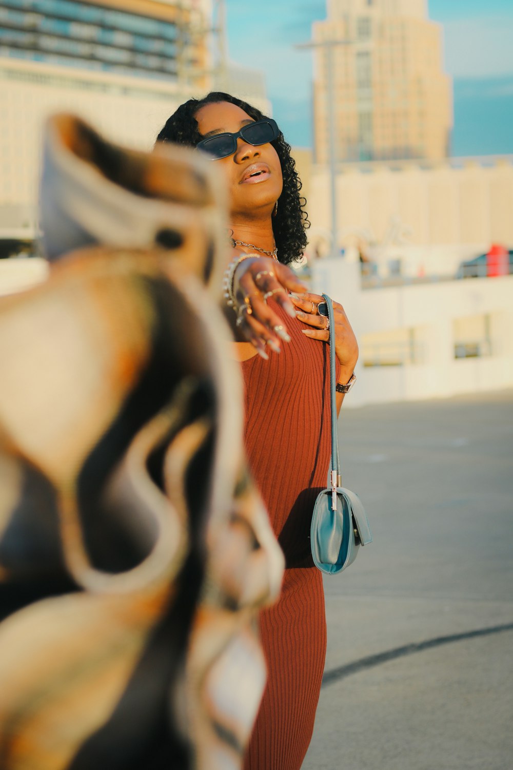 a woman in a red dress holding a blue purse