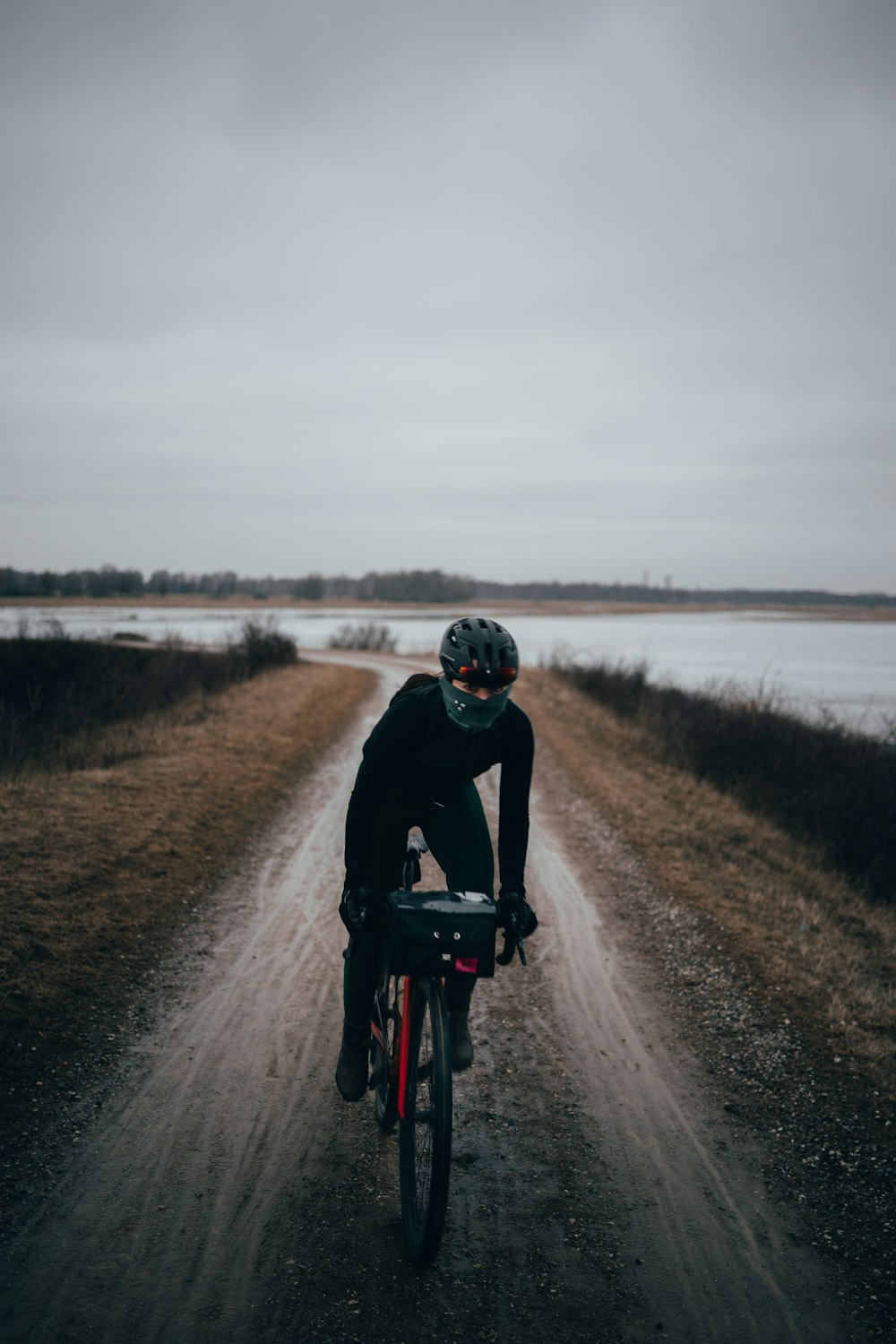 a man riding a bike down a dirt road