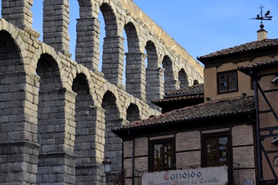 a large stone bridge over a river next to a tall building