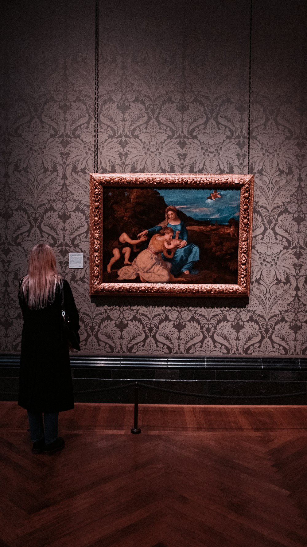 a woman looking at a painting in a museum