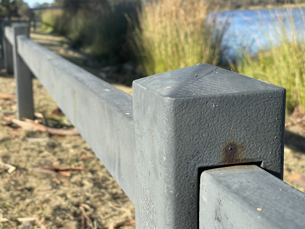 a close up of a metal fence near a body of water