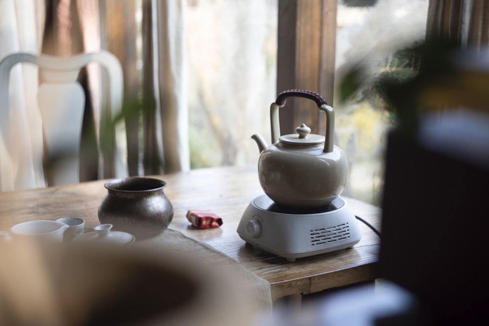 a tea kettle sitting on top of a wooden table