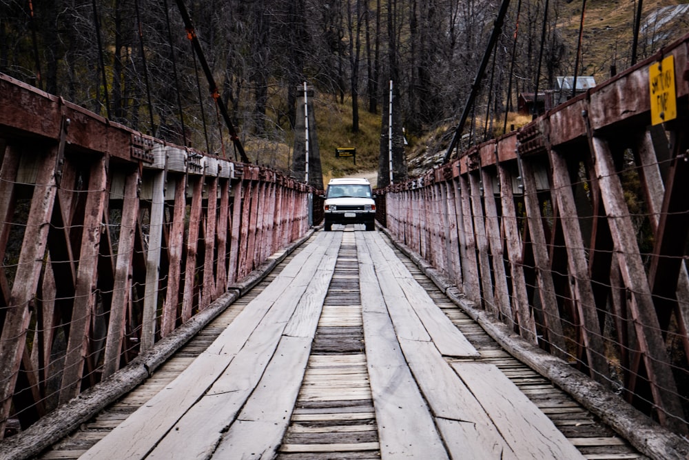 a truck is driving across a wooden bridge