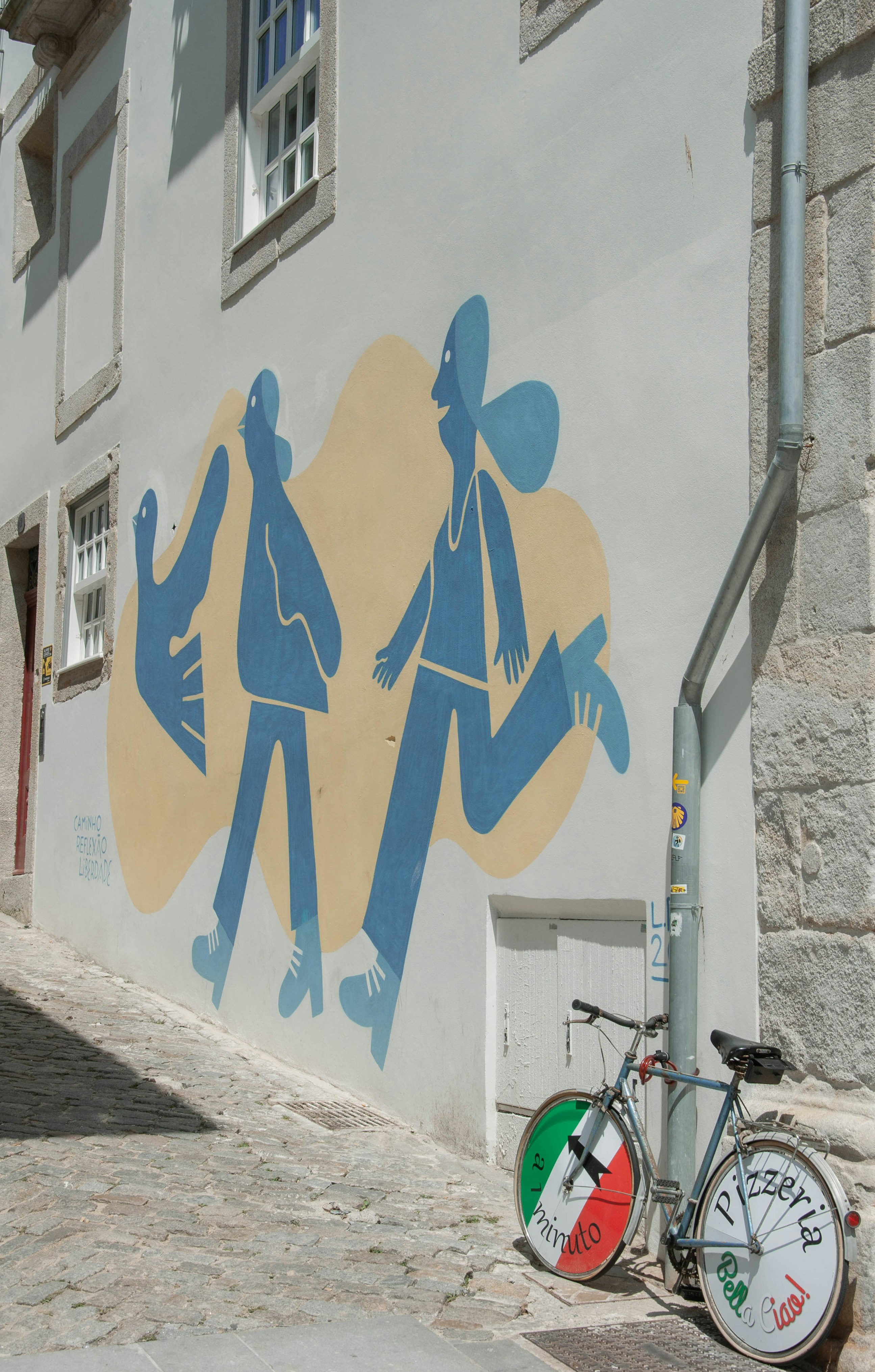 a bicycle parked next to a wall with a mural on it