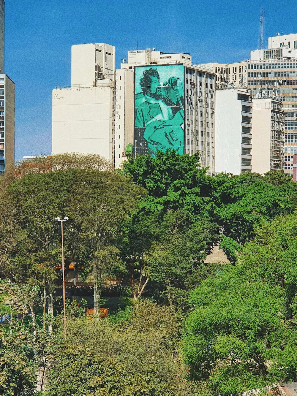 a city skyline with a large mural on the side of a building