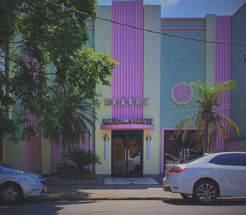 two cars parked in front of a multi - colored building