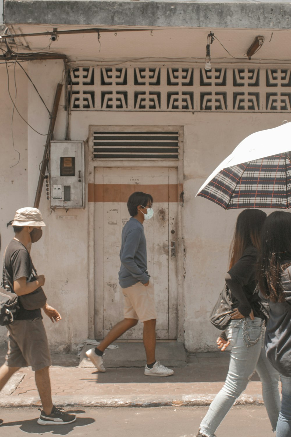 a group of people walking down a street holding umbrellas