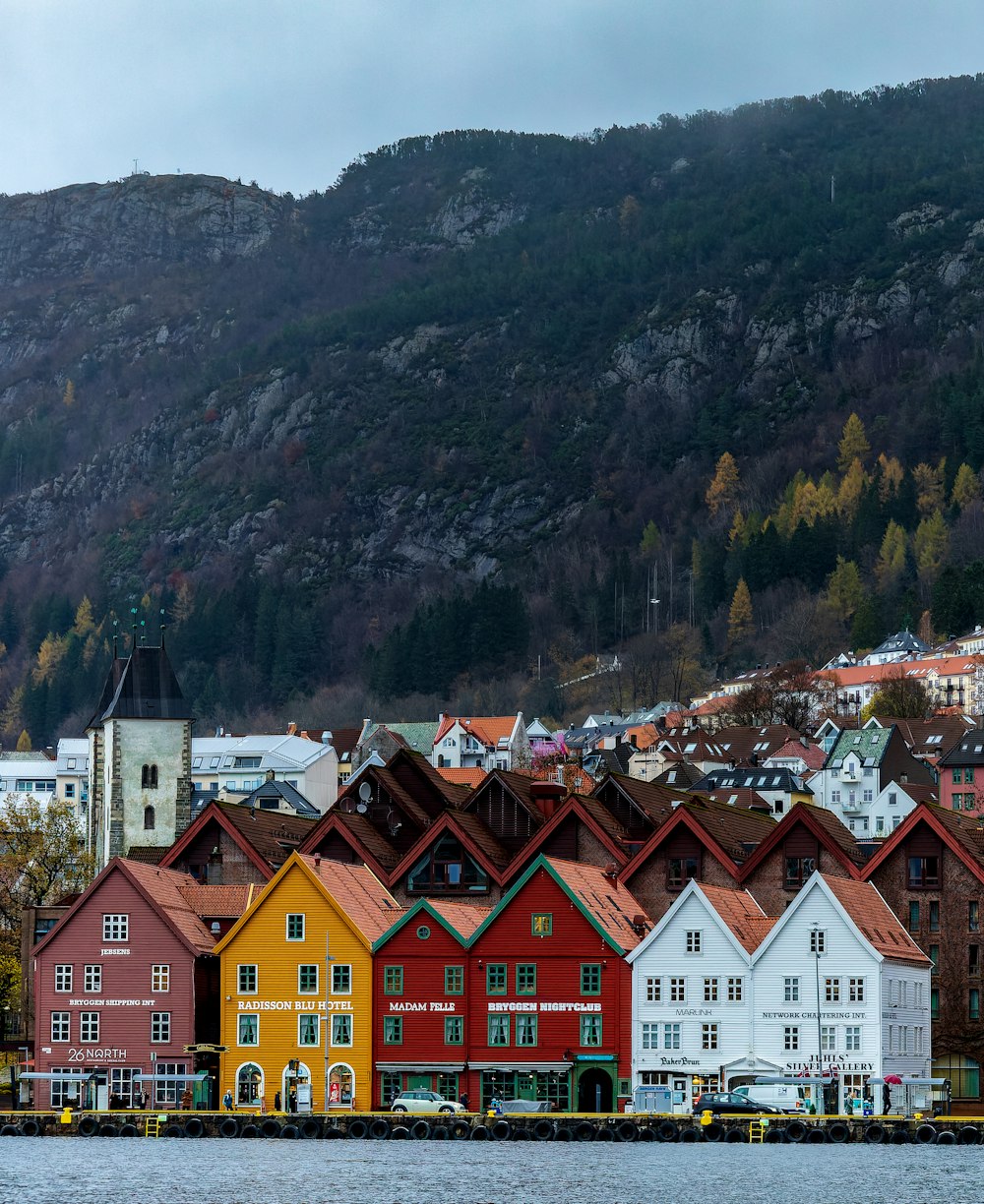 a row of colorful houses next to a body of water