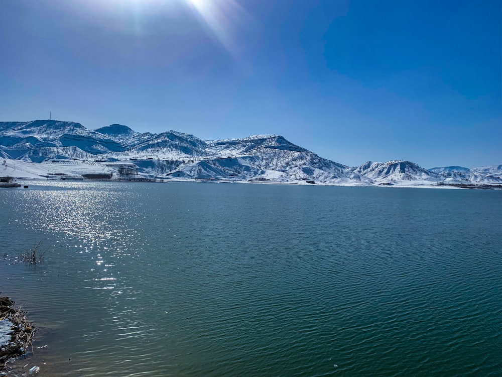 a large body of water surrounded by snow covered mountains