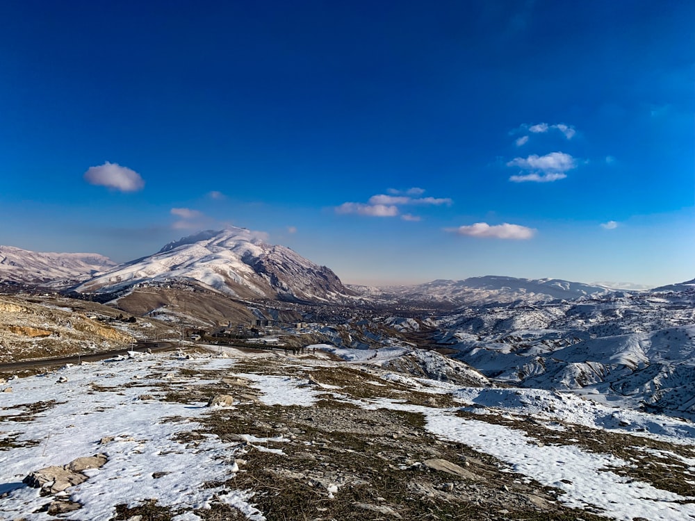 a view of a mountain range with snow on the ground