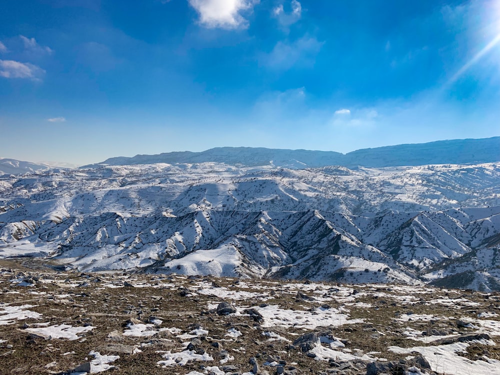 a snow covered mountain range under a blue sky