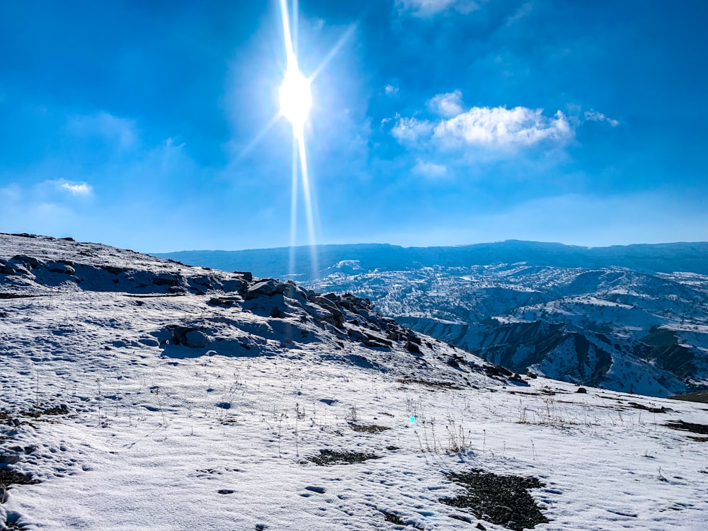 the sun shines brightly over a snowy mountain