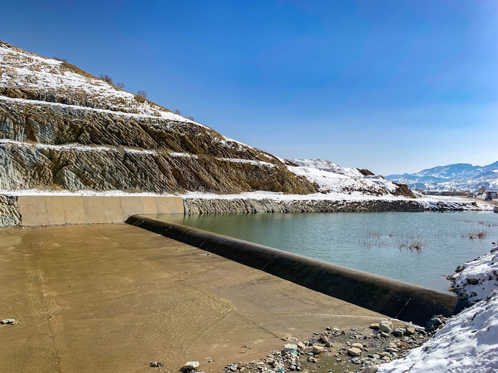 a large body of water surrounded by snow covered mountains