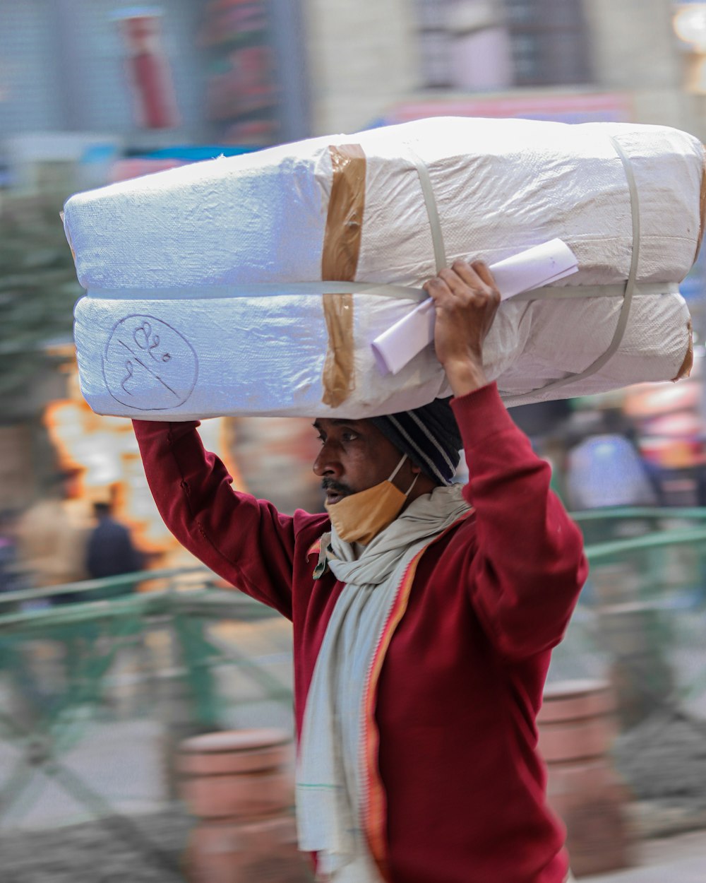 a man carrying a large bag on his head