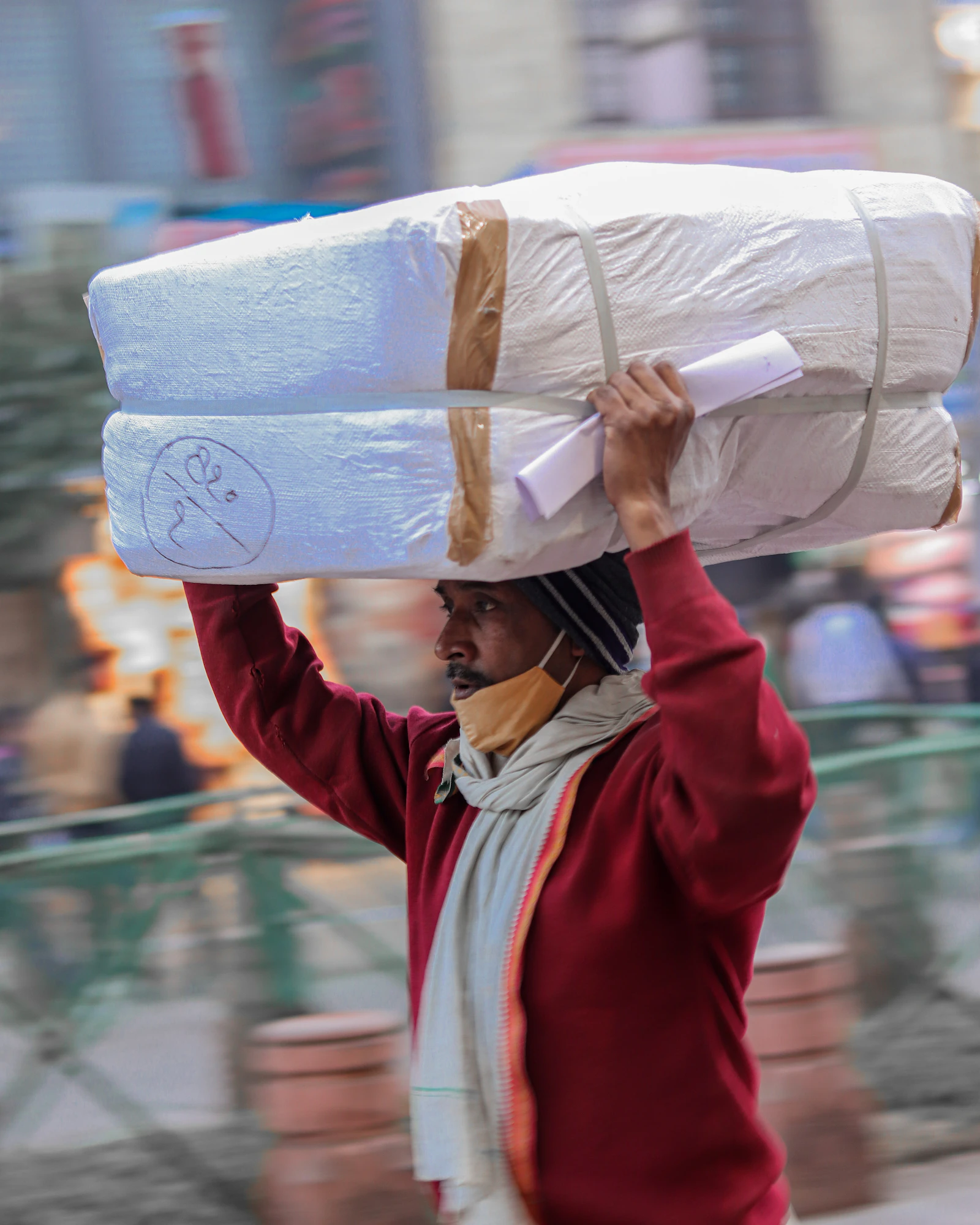 A porter carrying goods through Old Delhi lanes
