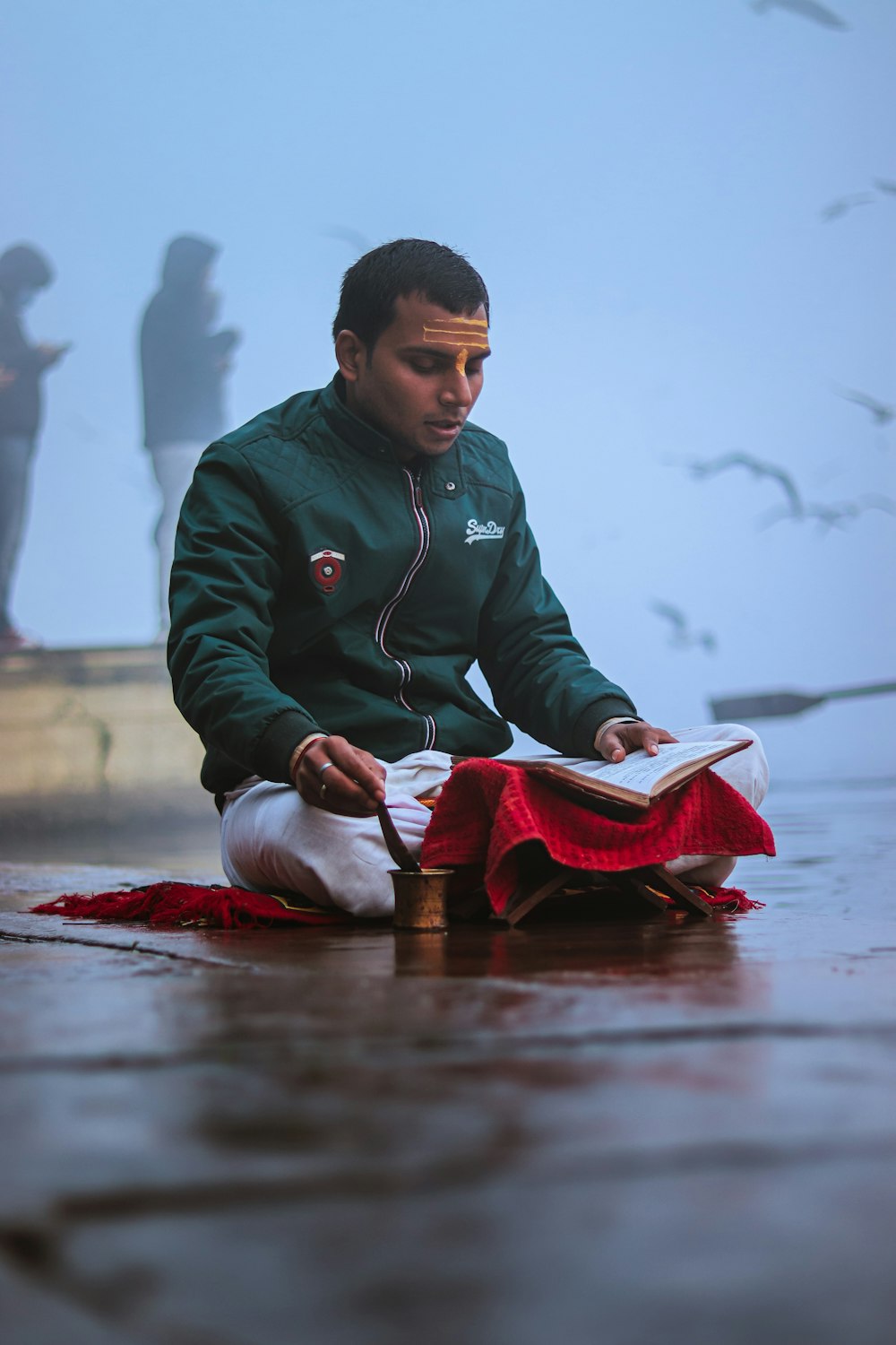 a man sitting on the ground reading a book