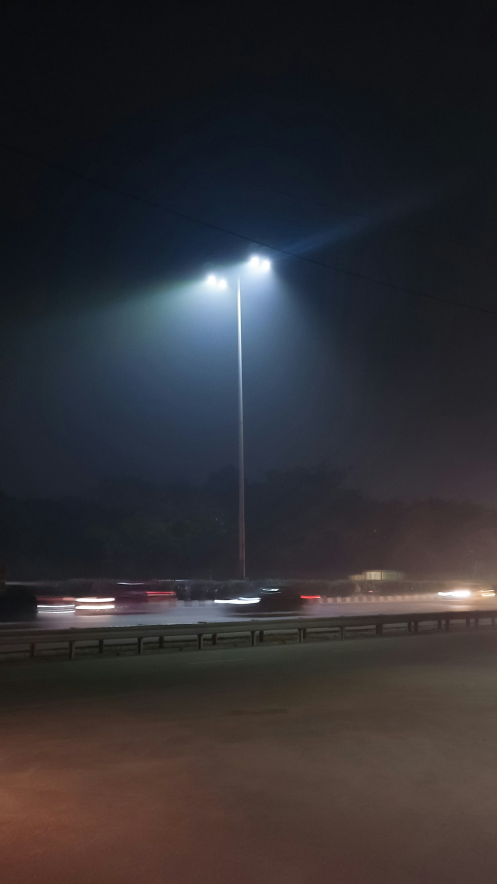 an empty parking lot at night with a street light in the background