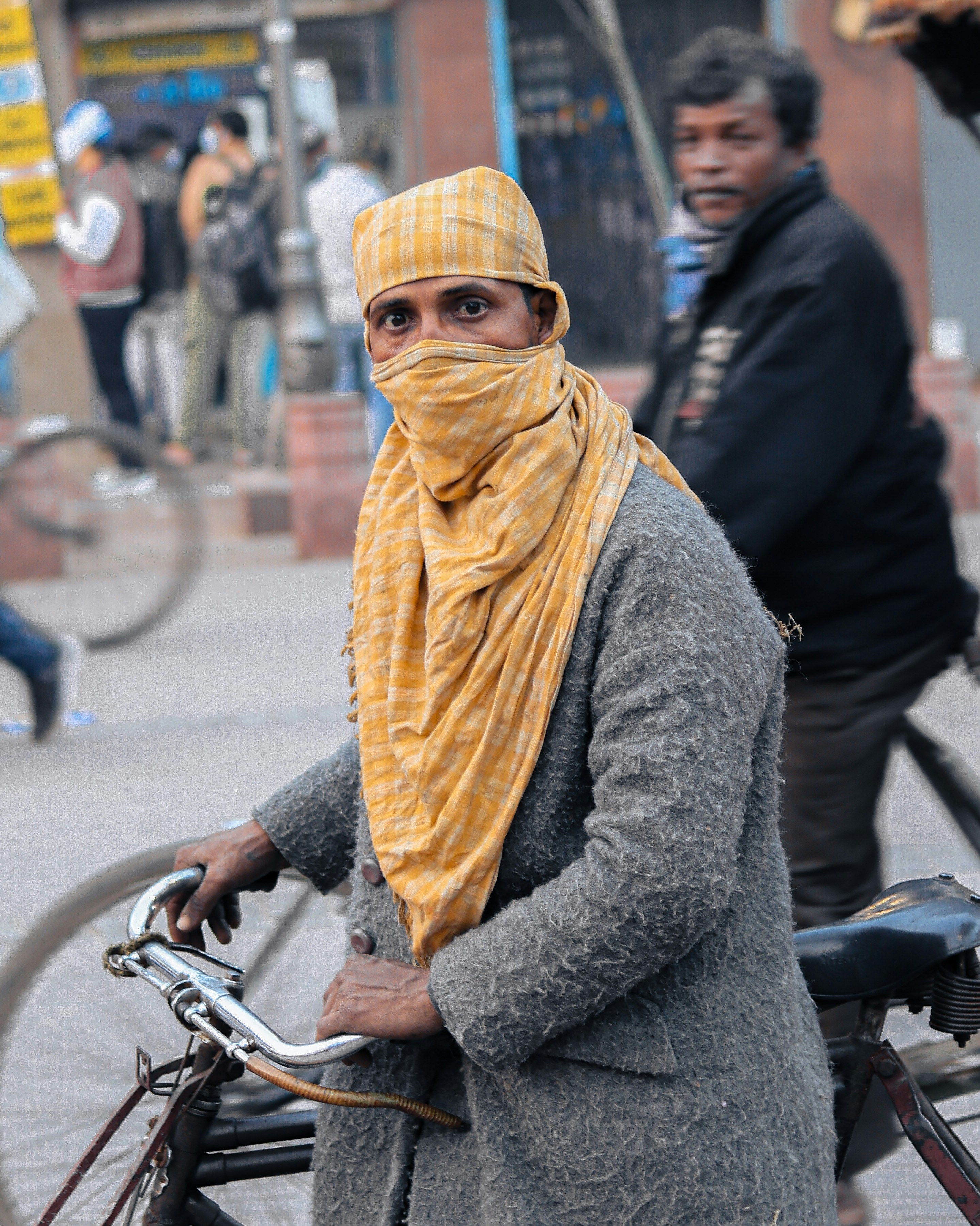 a woman in a yellow scarf is standing next to a bicycle