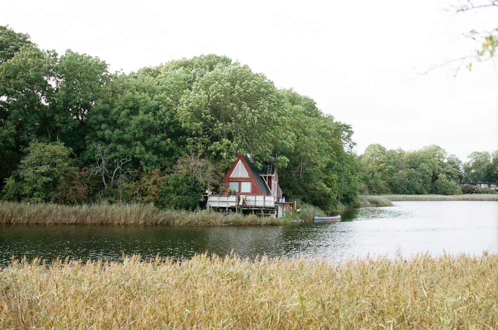 a house on a lake surrounded by trees