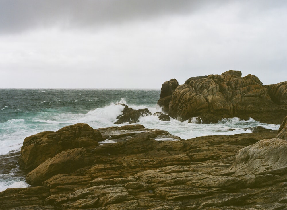 a rocky shore with waves crashing against the rocks