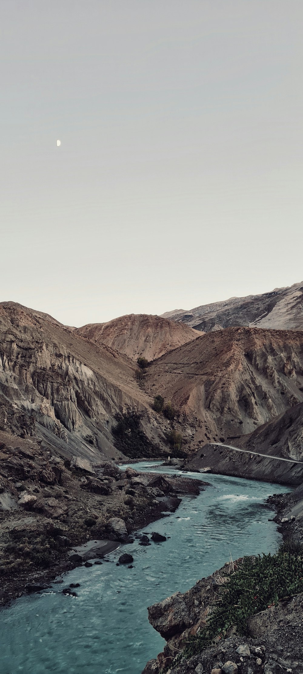 a river running through a valley surrounded by mountains