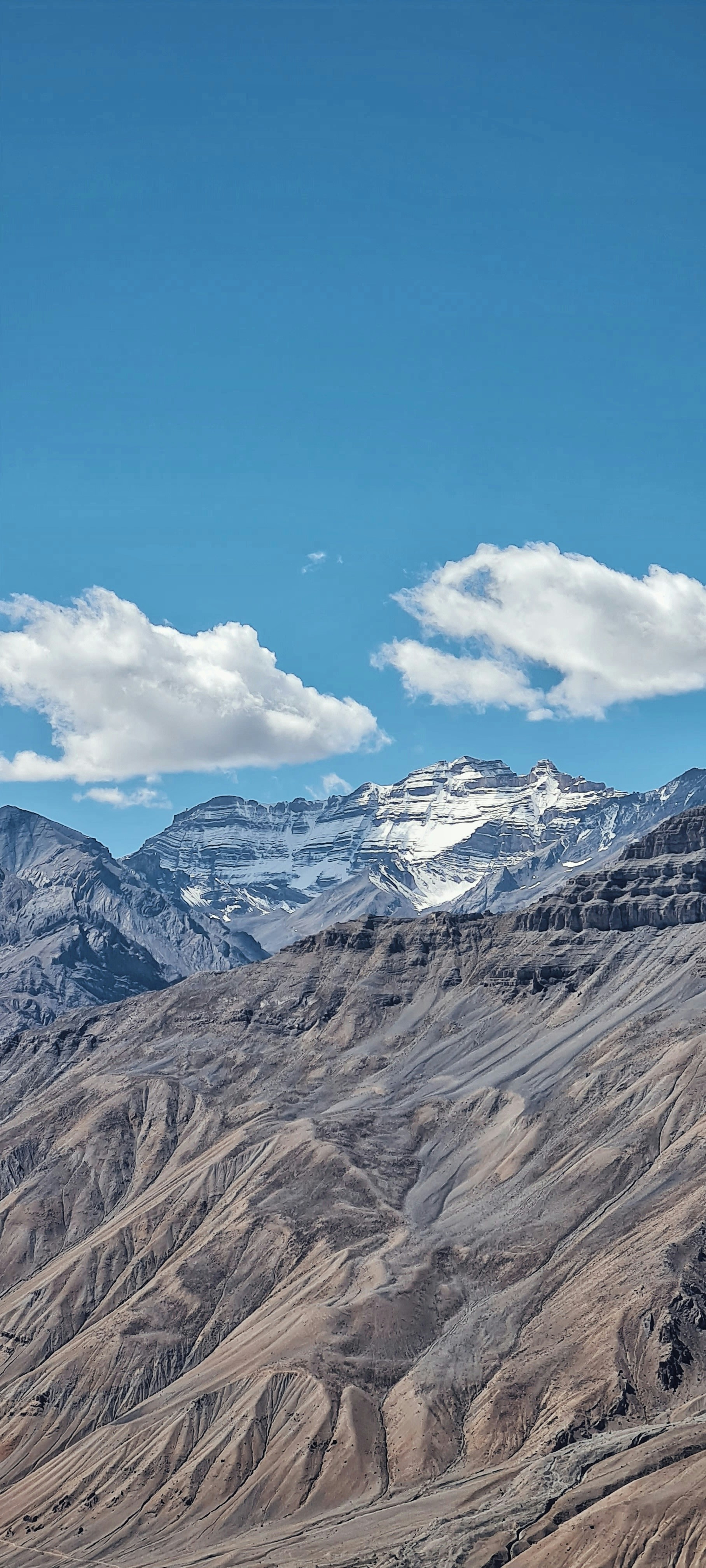 a mountain range with snow capped mountains in the distance