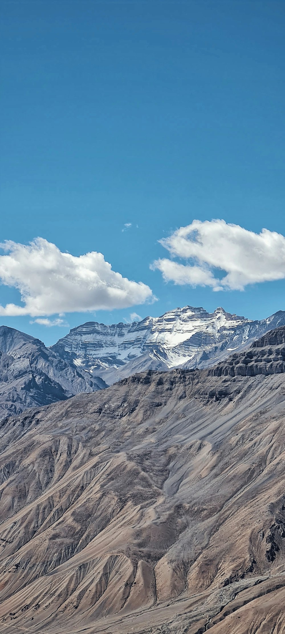 a mountain range with snow capped mountains in the distance