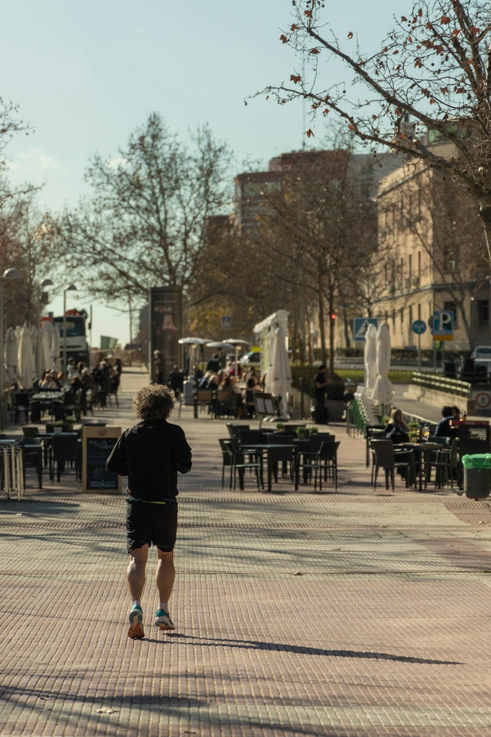 a man running down a sidewalk in a city