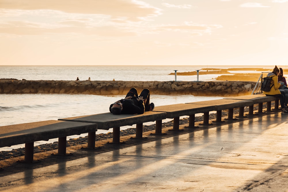 a person sitting on a bench next to the ocean