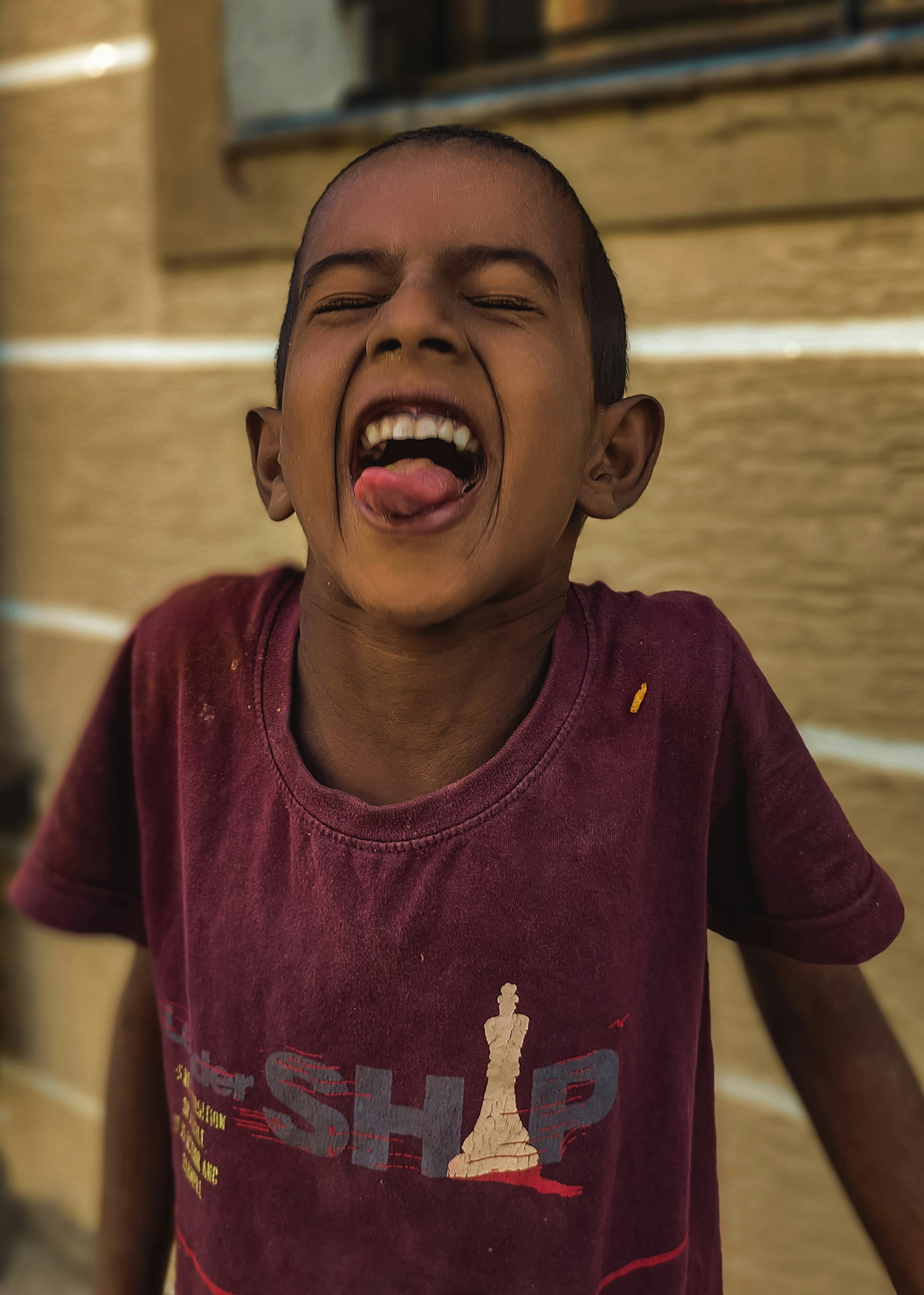 a young boy with his mouth open and tongue out