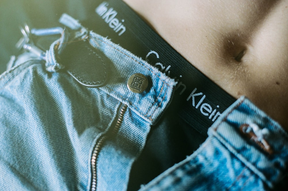 a close up of a person's stomach wearing a pair of jeans