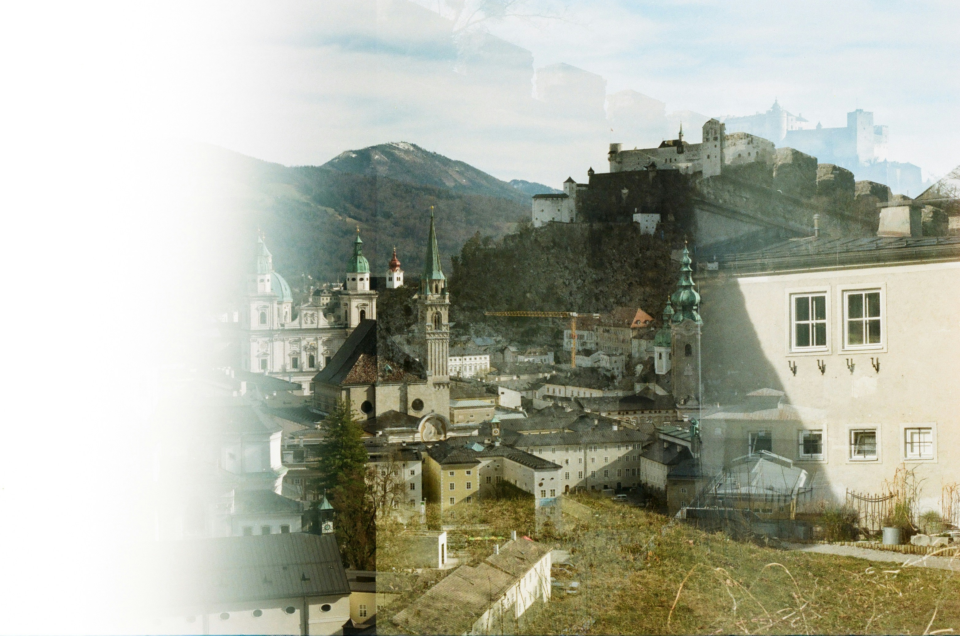a picture of a city with buildings and mountains in the background