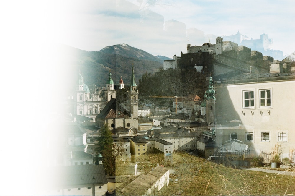 a picture of a city with buildings and mountains in the background