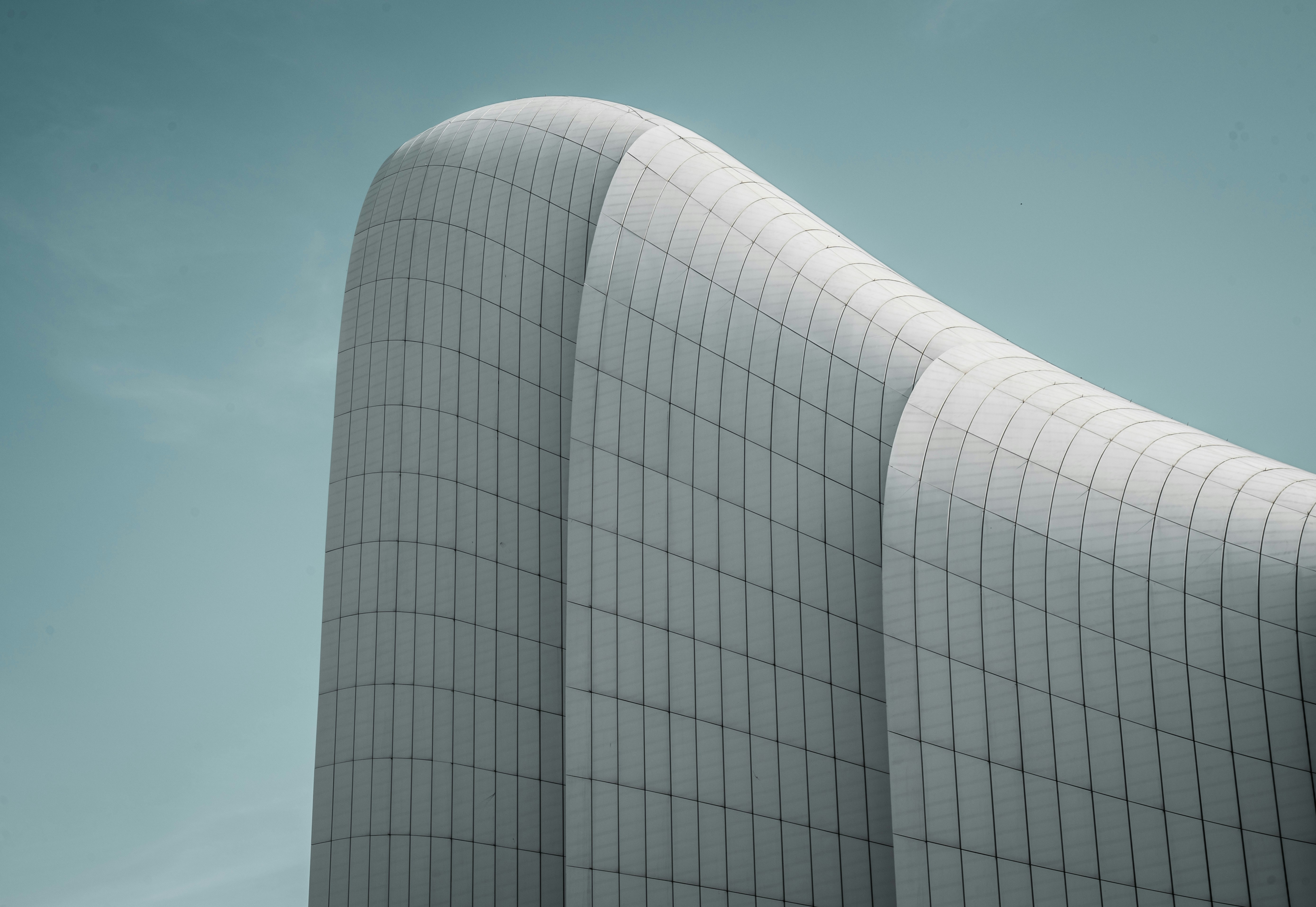 um edifício branco alto com um telhado curvo