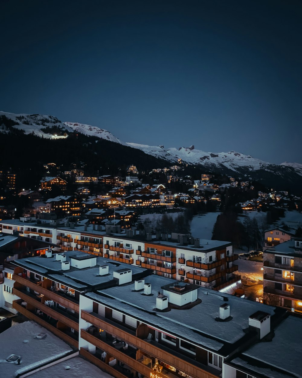 a view of a city at night with mountains in the background