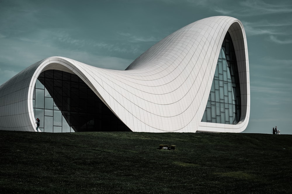 a large building with a curved roof on top of a hill