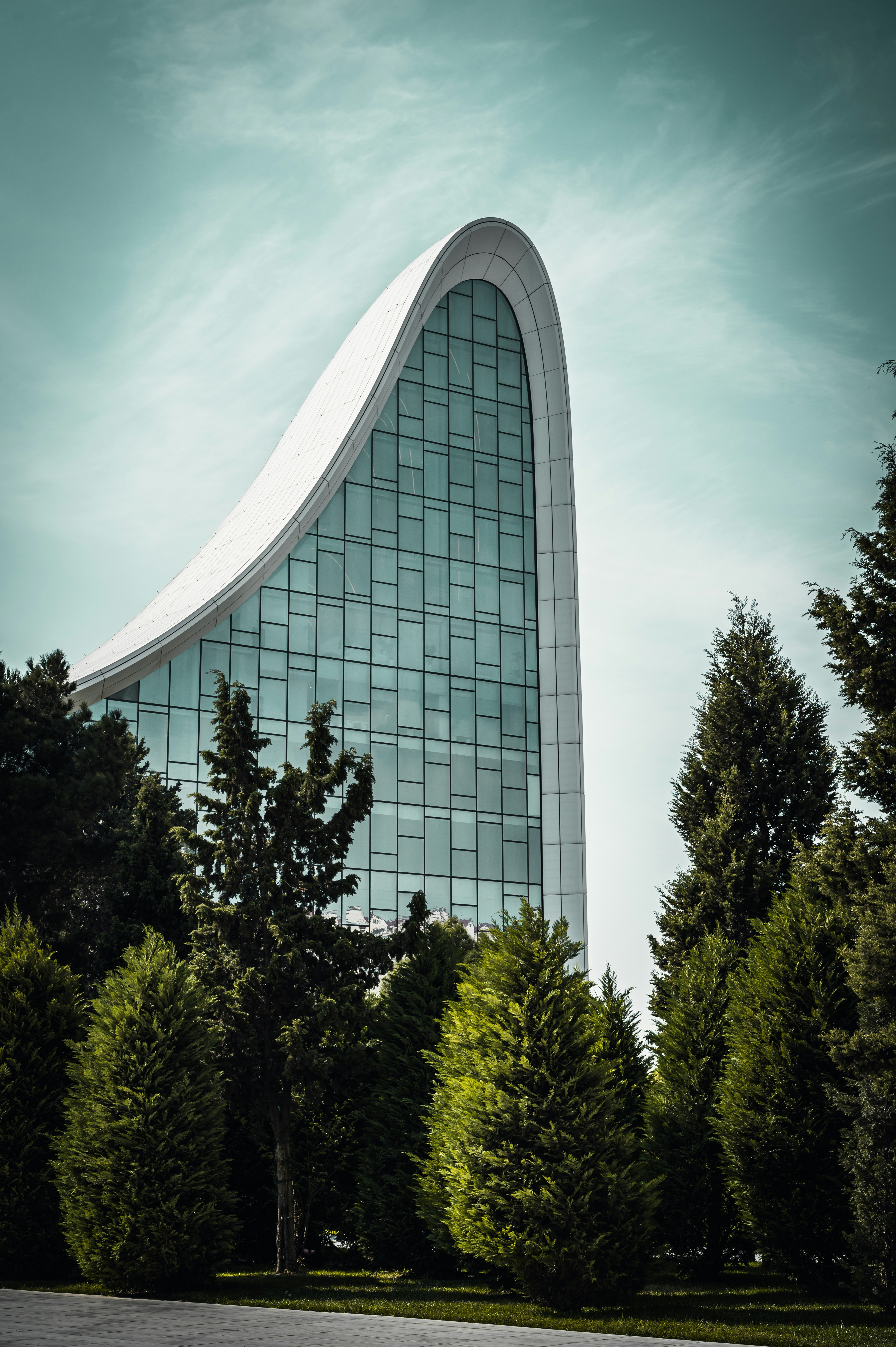 um edifício alto com um telhado curvo cercado por árvores