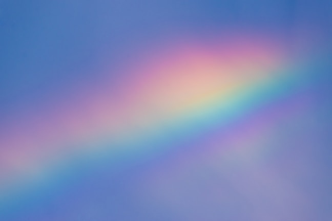 Colorful abstract album cover featuring a shimmering rainbow beneath soft clouds.