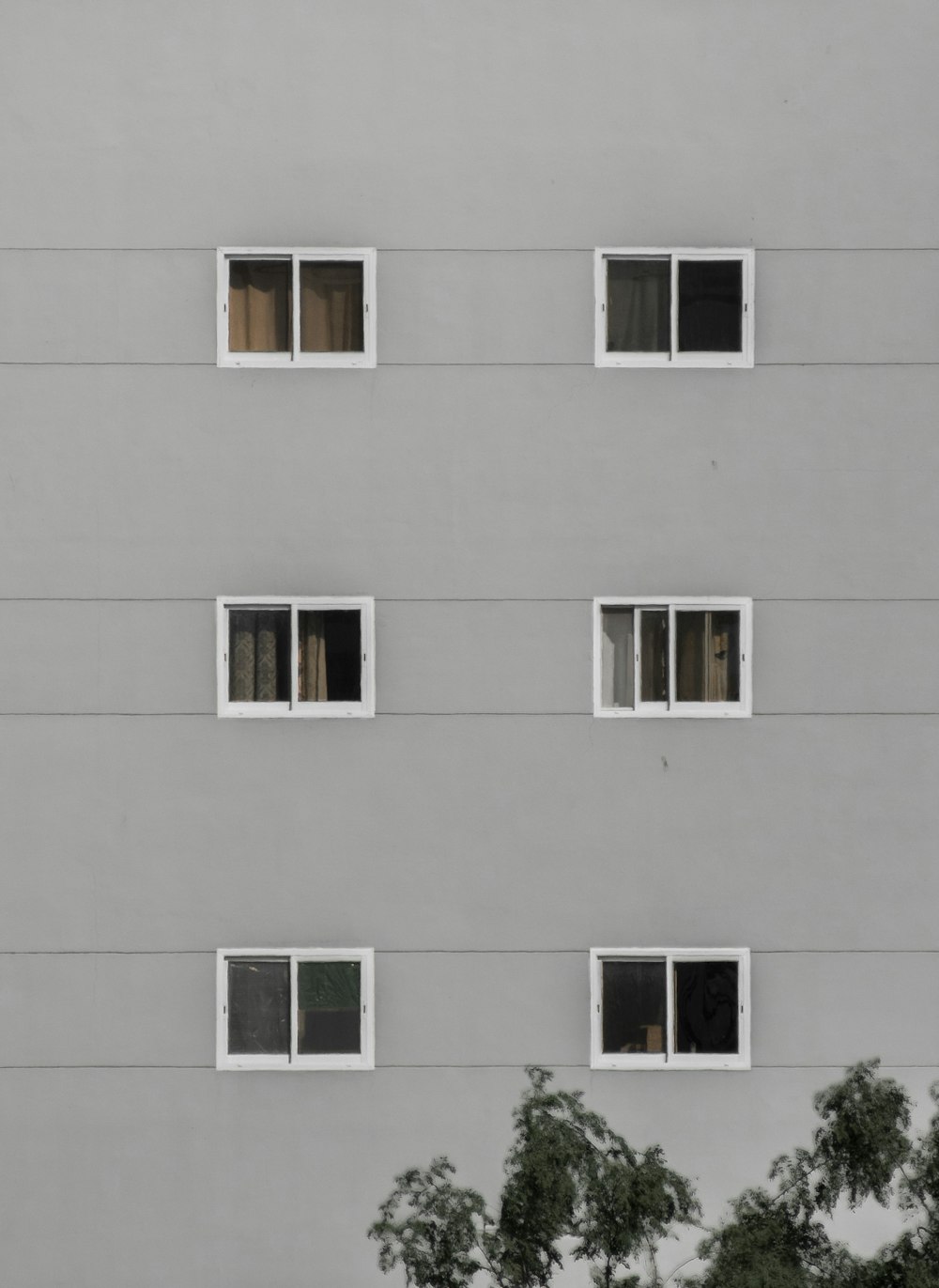 a tall building with many windows and trees in front of it