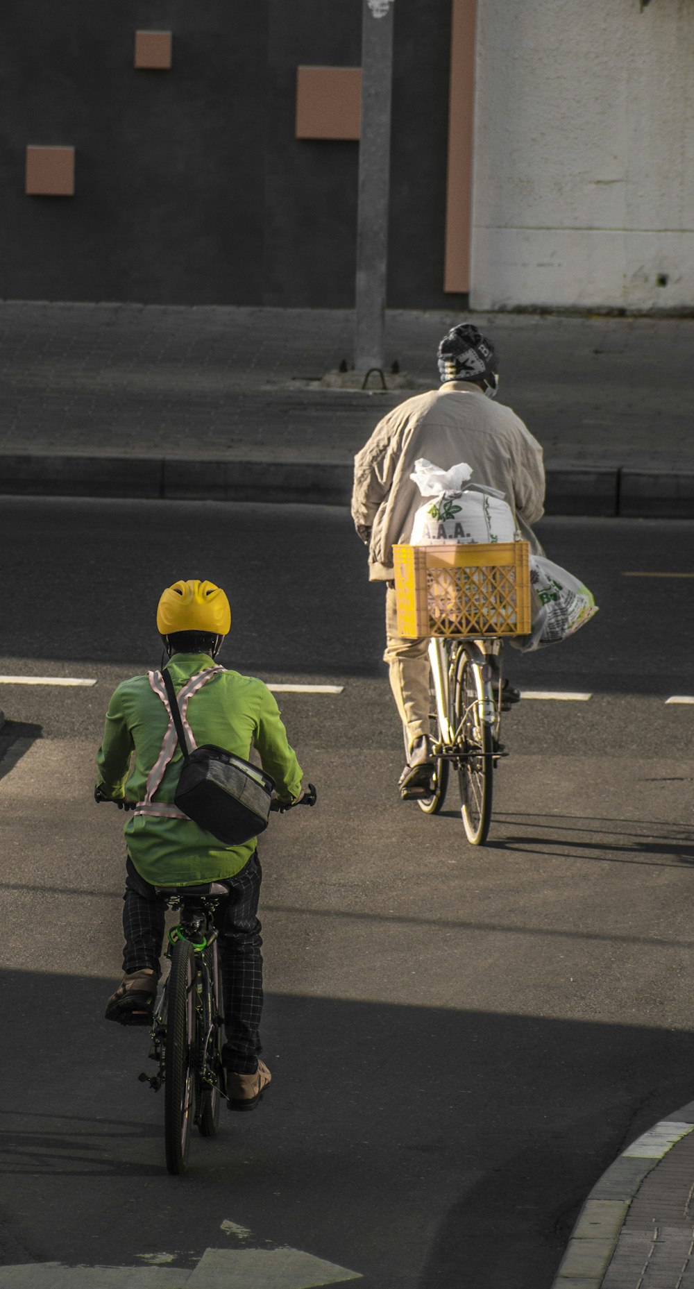 a man riding a bike down a street next to a person on a bike