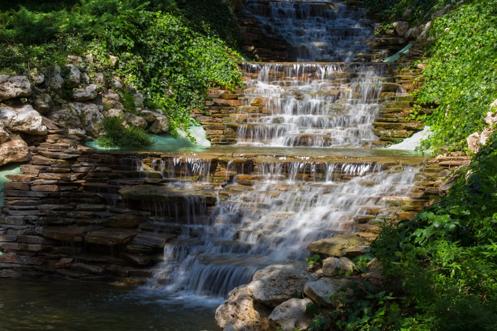 a small waterfall in the middle of a forest